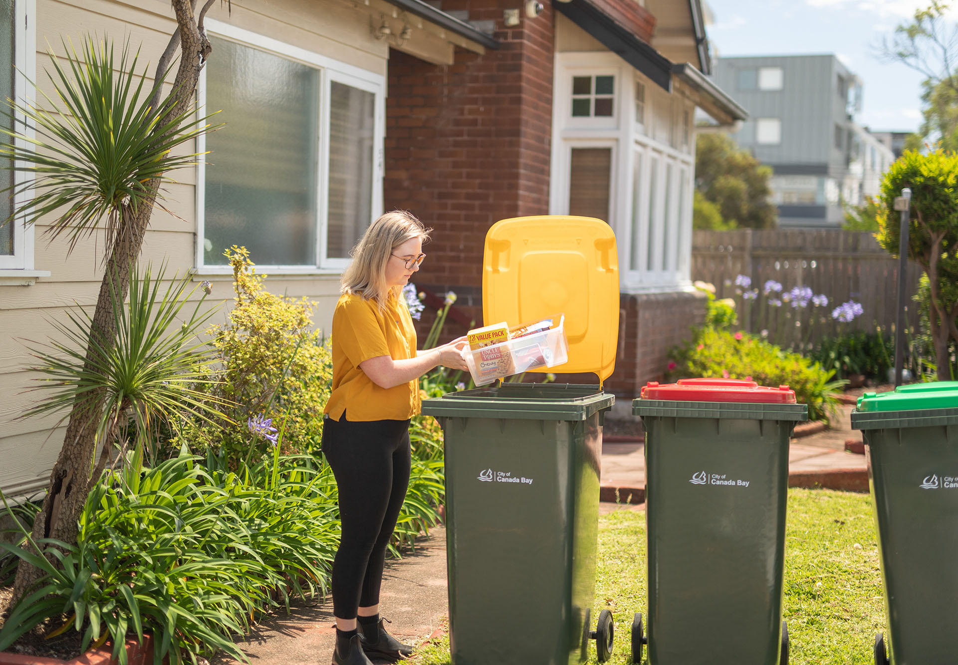 Image of woman putting recycling in a bin
