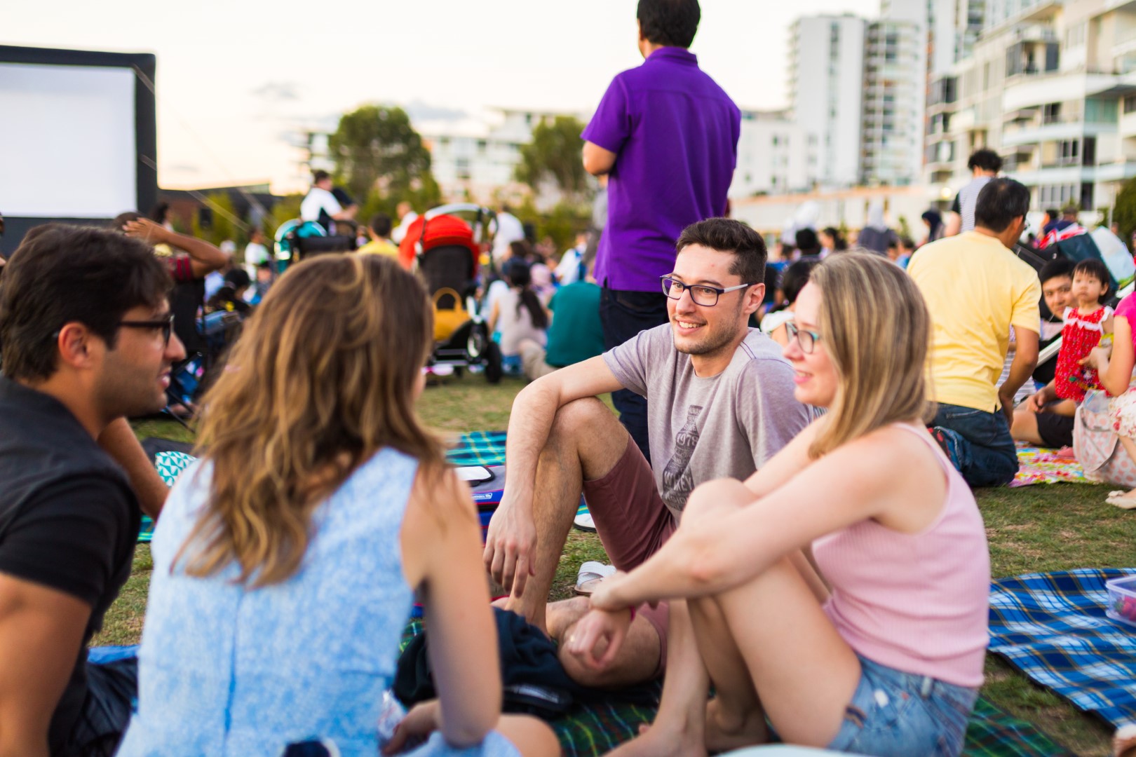 People sitting and chatting with movie screen