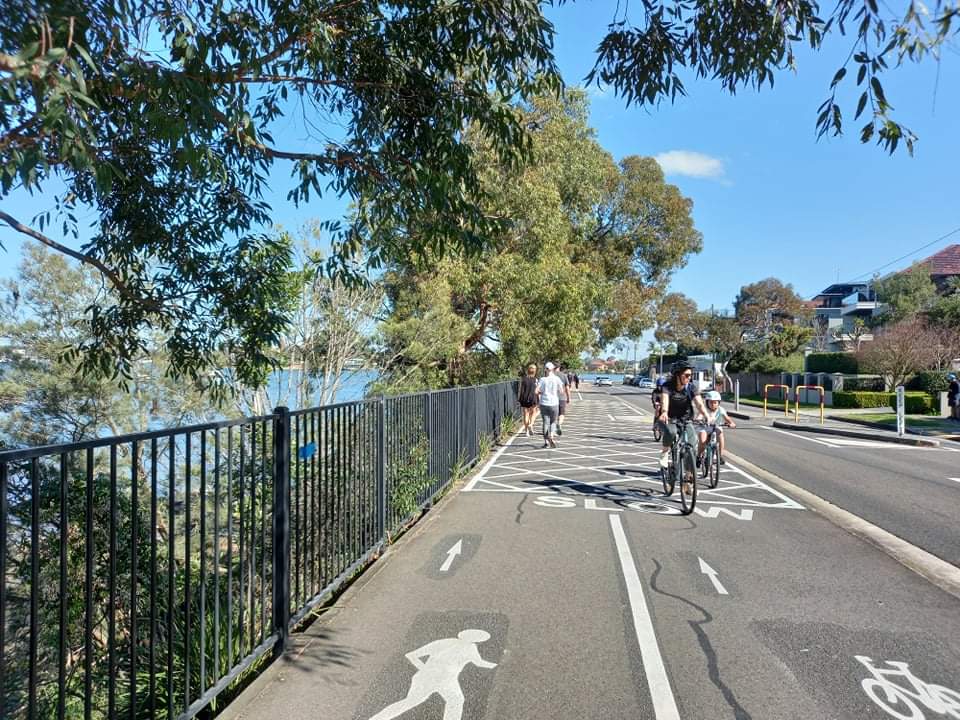 Cyclists and pedestrians traveling along the Bay Run on a sunny day