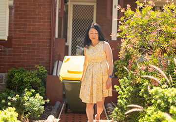 Image of woman putting her bins out