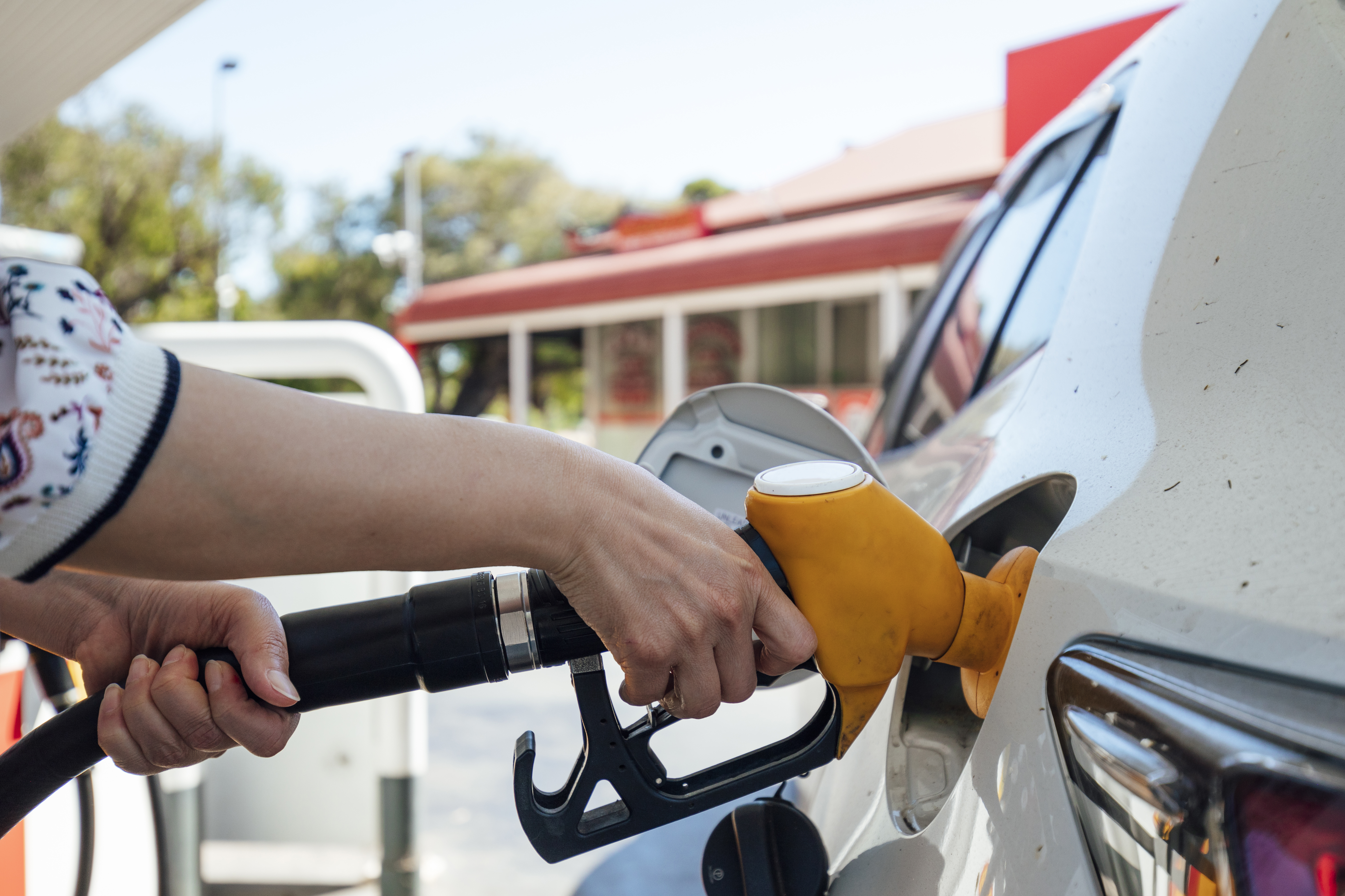 Image of woman's hand pumping petrol
