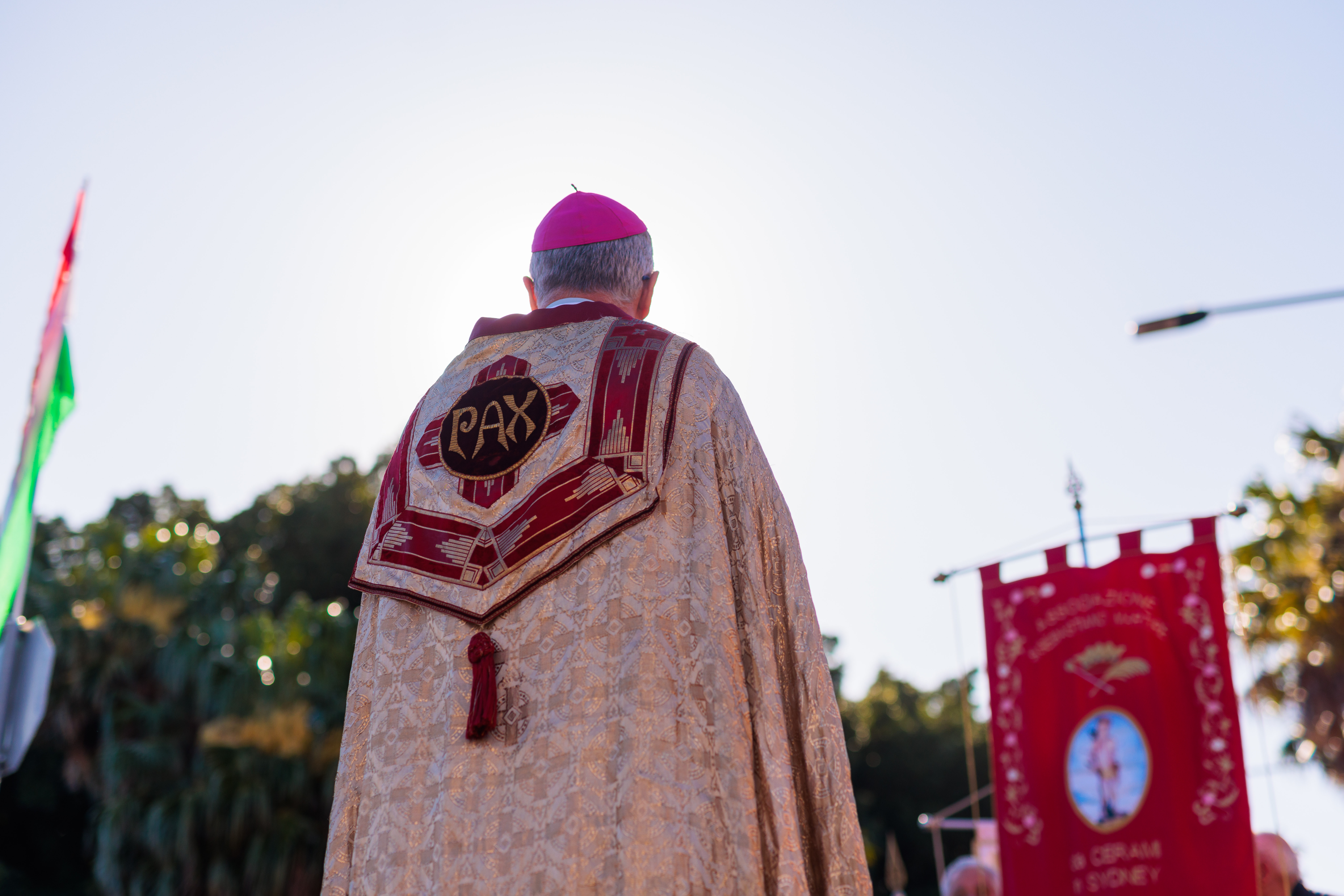 back photo of bishop and procession flag