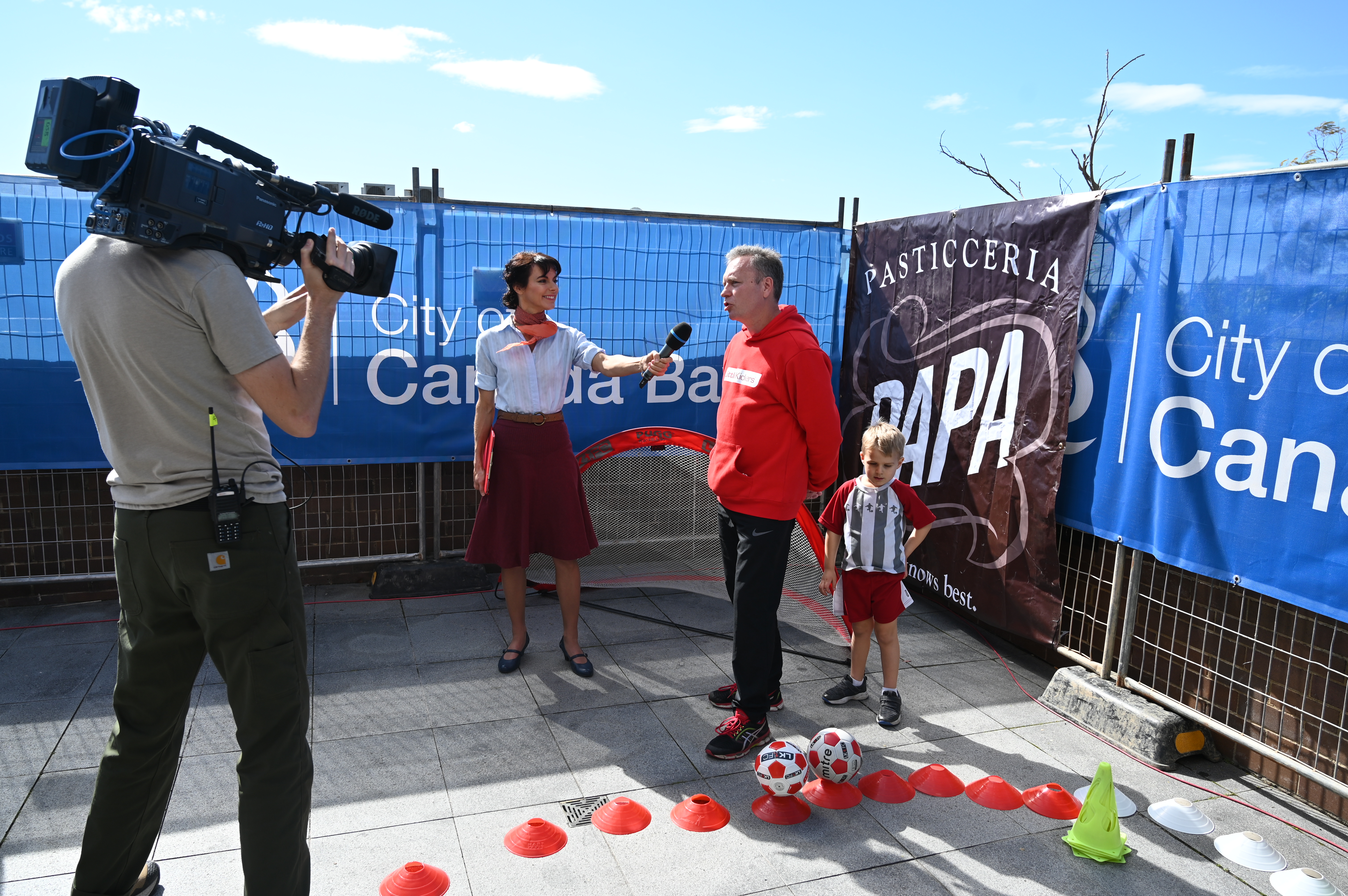 lady interview man and child playing soccer