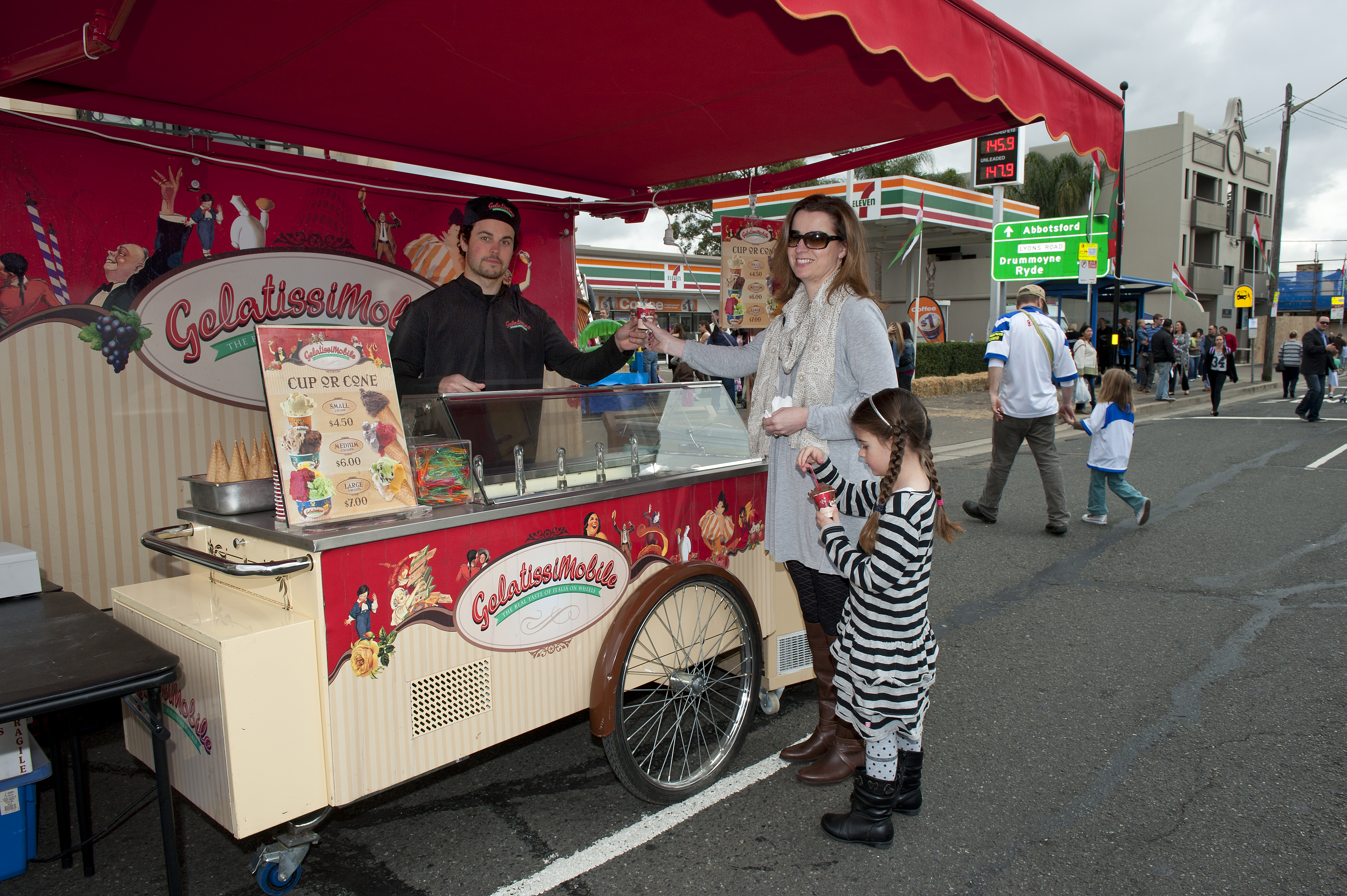 mother and daughter ordering ice cream at cart