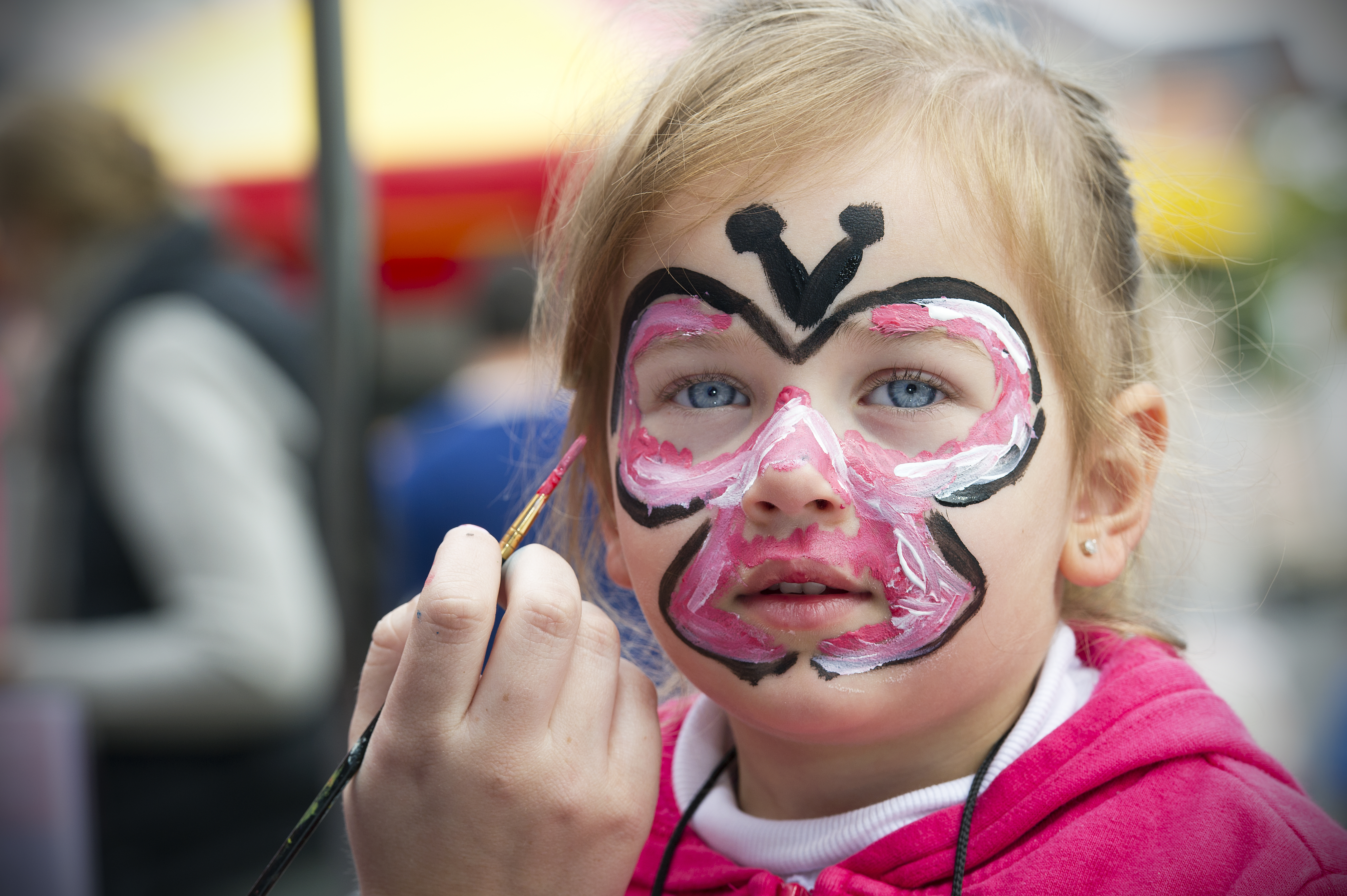 kids face getting face painted on