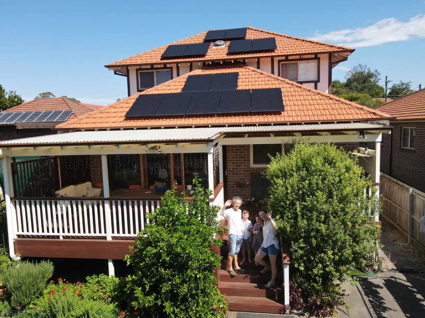 Family in front of home with solar panels