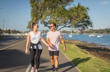 Man and woman walking along the Bay Run