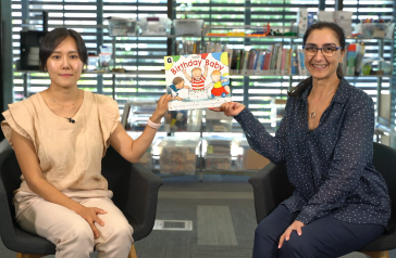 Julie and Liz holding up Eve's Ducklings picture book