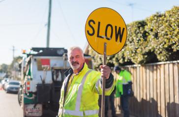 Image of male Council worker in fluoro shirt with stop sign