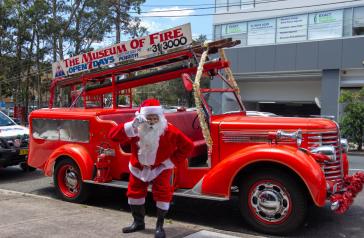 Santa in front of vintage fire truck